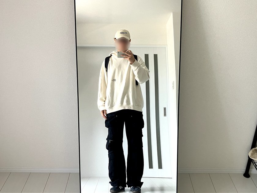 白パーカーと黒ワイドカーゴパンツに無印リュックを合わせた高身長メンズの正面コーデ